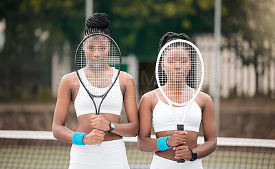 Buy stock photo Serious tennis players holding their rackets. Portrait of young tennis players covering their faces with rackets on the court. African american girls ready for a tennis match.