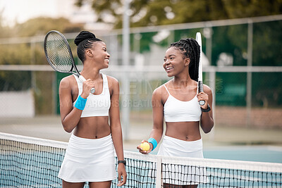Buy stock photo Friends bonding after a tennis match. African american woman talking after a game of tennis. Young women walking and talking on the tennis court. Carefree girls walking by the net on the tennis court