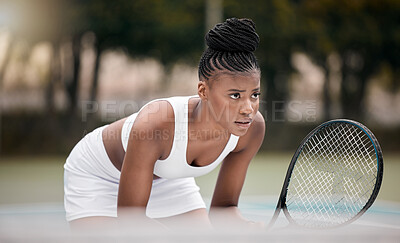 Buy stock photo Focused woman waiting during a tennis match. Young african american woman holding her racket during a game of tennis. Professional athlete standing on a tennis court. Young woman playing tennis match