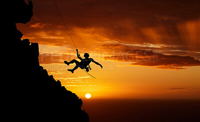 Buy stock photo Sunset sky abseiling, mountain silhouette and hiking man hanging on shadow rope. Fitness risk, adventure freedom challenge and strong, surreal nature adrenaline and cliff climbing on orange landscape