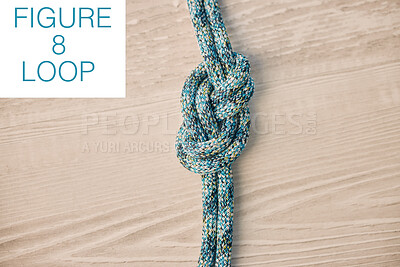 Above shot of hiking rope tied in a knot against a wooden background in studio. Figure 8 knot, A knot for every situation. Strong rope to secure safety while mountain climbing or doing extreme sports