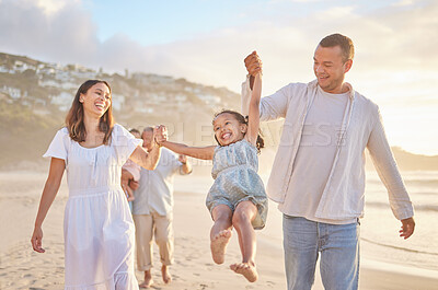 Buy stock photo Cute little girl swinging while holding hands with her parents. Young mom and daf walking hand in hand with their daughter and lifting her while walking on the beach. Family fun in the summer sun