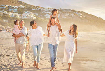 Buy stock photo Happy mixed race family of six walking on the beach. Two cute sisters enjoying the sand and sea with their mom, dad, grandmother and grandfather. Grandparents with their kids and grandchildren