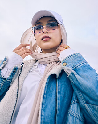 Buy stock photo Portrait, fashion or low angle with a muslim woman outdoor in a cap, sunglasses and scarf for contemporary style. Islam, faith or hijab with a trendy young arab person posing alone in modern eyewear