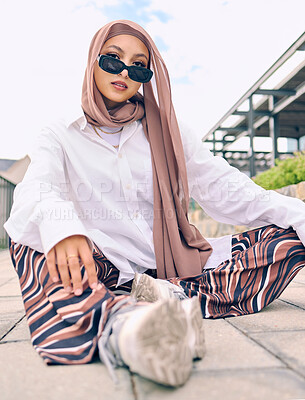 Buy stock photo Portrait, fashion or tradition with a muslim woman outdoor in sunglasses and a scarf for contemporary style. Islam, faith or hijab with a trendy young islamic person sitting outside in modern clothes