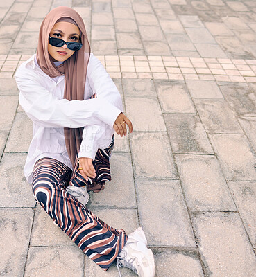 Buy stock photo Portrait, fashion or city with a muslim woman outdoor in sunglasses and a scarf for urban style. Islam, religion or arabic and a trendy young saudi person sitting outside in modern clothes with space