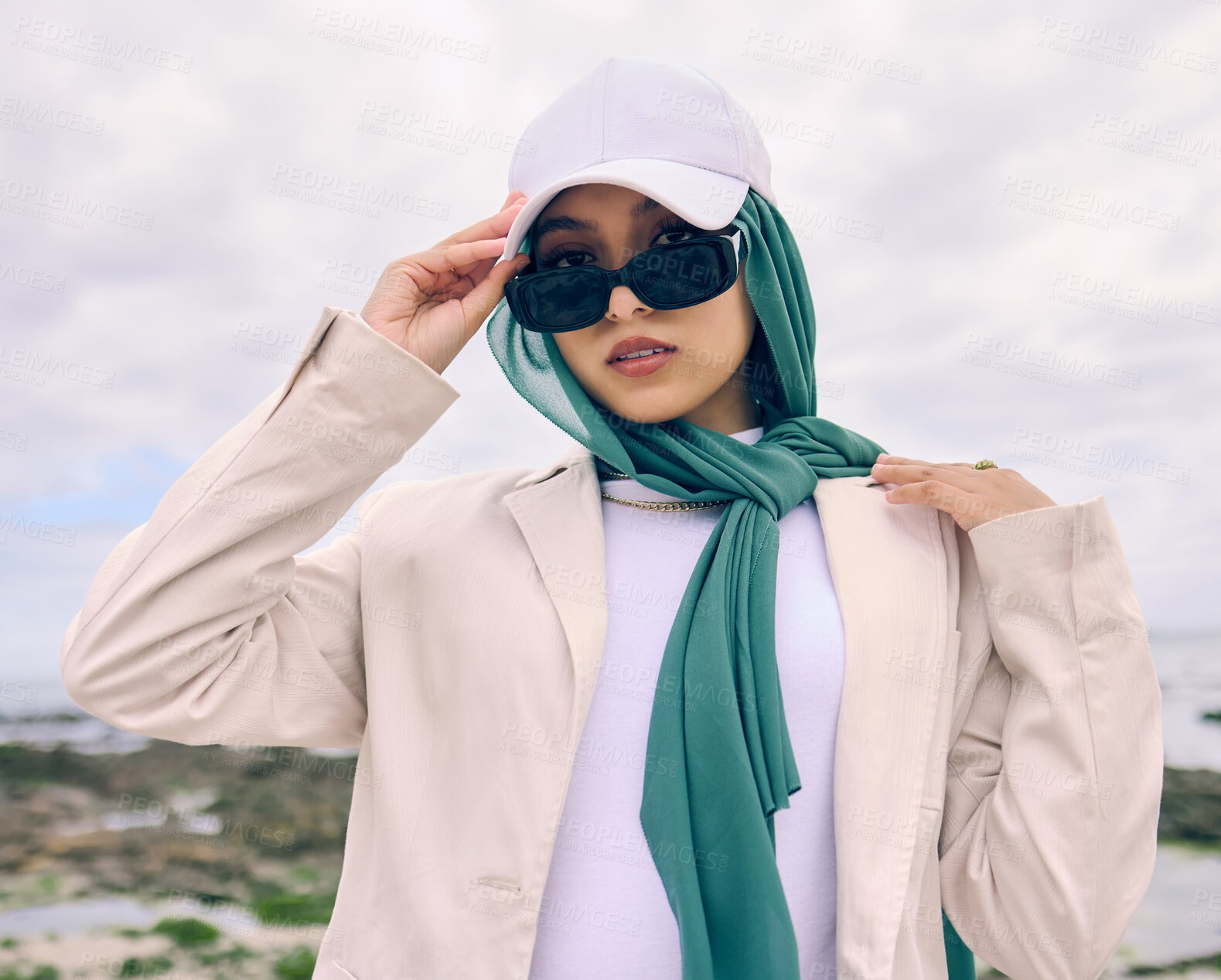 Buy stock photo Portrait, fashion or sunglasses with an islamic woman outdoor in a cap and scarf for contemporary style. Muslim, faith or hijab for religion with a trendy young arab person outside in modern clothes