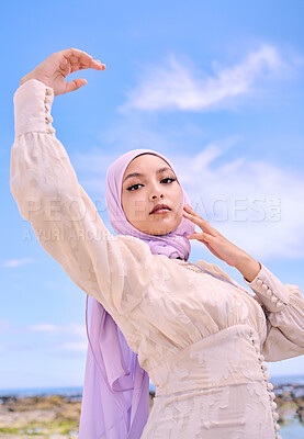 Buy stock photo Portrait, fashion or faith with a muslim woman on a blue sky background in a scarf for modern style. Islam, religion and hijab with a trendy young arab person posing outside in contemporary clothes