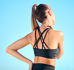 Rearview beautiful woman practising yoga exercise on the beach. Young female athlete suffering with neck pain while working out outside. Struggling with cramp, soreness or stiffness of the muscle