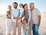 Happy family at the beach. Family relaxing on the beach during a holiday. Parents and grandparents bonding with children by the ocean. Smiling caucasian family resting on the beach together
