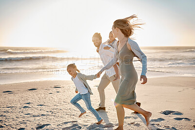 Buy stock photo Carefree family having fun on the beach. Happy family playing on the beach on holiday. Caucasian family enjoying a beach vacation. Parents bonding with their children on the beach