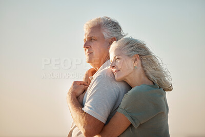 Buy stock photo couple embracing on the beach. Mature couple enjoying the view on the beach. Senior couple bonding on the beach. Mature couple being affectionate on the beach. Senior couple on vacation by the sea