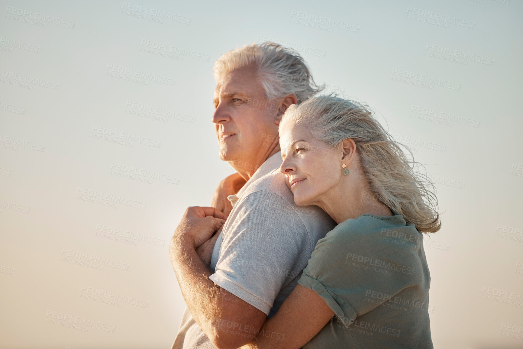 Buy stock photo couple embracing on the beach. Mature couple enjoying the view on the beach. Senior couple bonding on the beach. Mature couple being affectionate on the beach. Senior couple on vacation by the sea