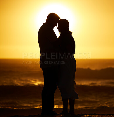 Buy stock photo Silhouette, couple and love on a beach at sunset for vacation or holiday outdoor. Romantic man and woman hug in nature with creative sky, space and ocean for care, shadow art and travel or freedom 
