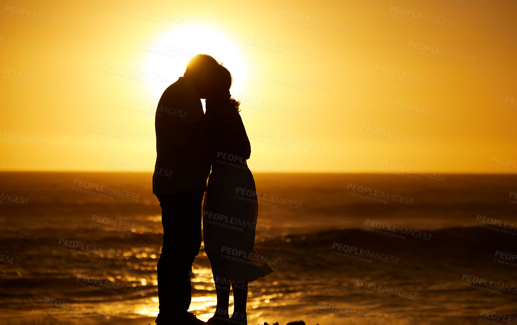 Buy stock photo Couple, siilhouette and kiss at sunset on a beach for vacation, holiday or mockup outdoor. Romantic man and woman in nature with creative sky, care and ocean for love, shadow art and travel freedom 