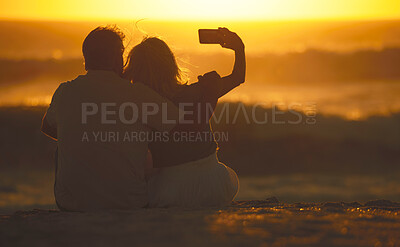 Buy stock photo Travel, couple and selfie at sunset on a beach for vacation or holiday outdoor. Behind romantic man and woman in nature with peace, calm and ocean for quality time, love and freedom or photo memory