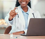 Smiling doctor sitting at her desk holding a vial of covid vaccine. African american doctor holding a bottle of corona virus antidote. Medical physician holding the covid cure