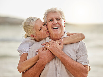 Buy stock photo Portrait of a happy senior caucasian couple standing and embracing each other on a day out at the beach. Mature husband and wife smiling and showing affection in nature