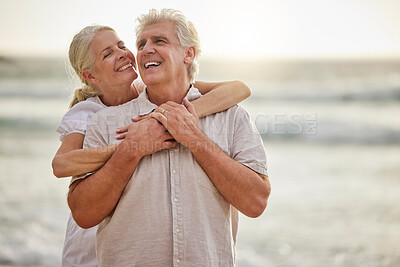 Closeup of a happy senior caucasian couple standing and embracing each other on a day out at the beach. Mature husband and wife smiling and showing affection in nature