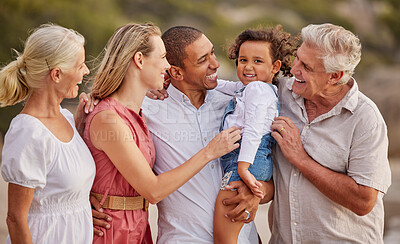 Buy stock photo Closeup of a senior caucasian couple at the beach with their children and grandchild. Mixed race family relaxing on the beach having fun and bonding