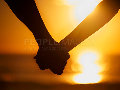 Buy stock photo Closeup of an silhouette couple holding hands at the beach during a beautiful sunset