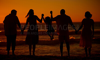 Buy stock photo Rear view of a three generation family silhouetted on the beach while jumping together. Cheerful family with two children, two parents and grandparents holding hands and watching the sunset at the beach