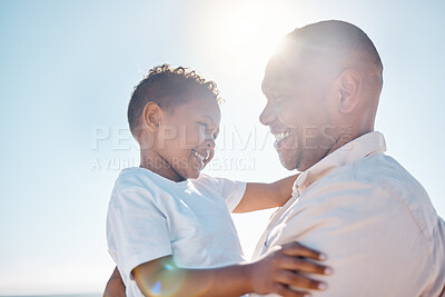 Buy stock photo Smiling mixed race father carrying his small son on beach with copyspace. Adorable, happy, little, hispanic boy bonding with his single parent outside over a weekend. Man and child enjoying free time