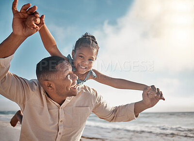 Smiling mixed race single father pretending to fly with his little daughter on a beach with copyspace. Adorable, happy, hispanic girl bonding with parent and playing. Man and child enjoying free time