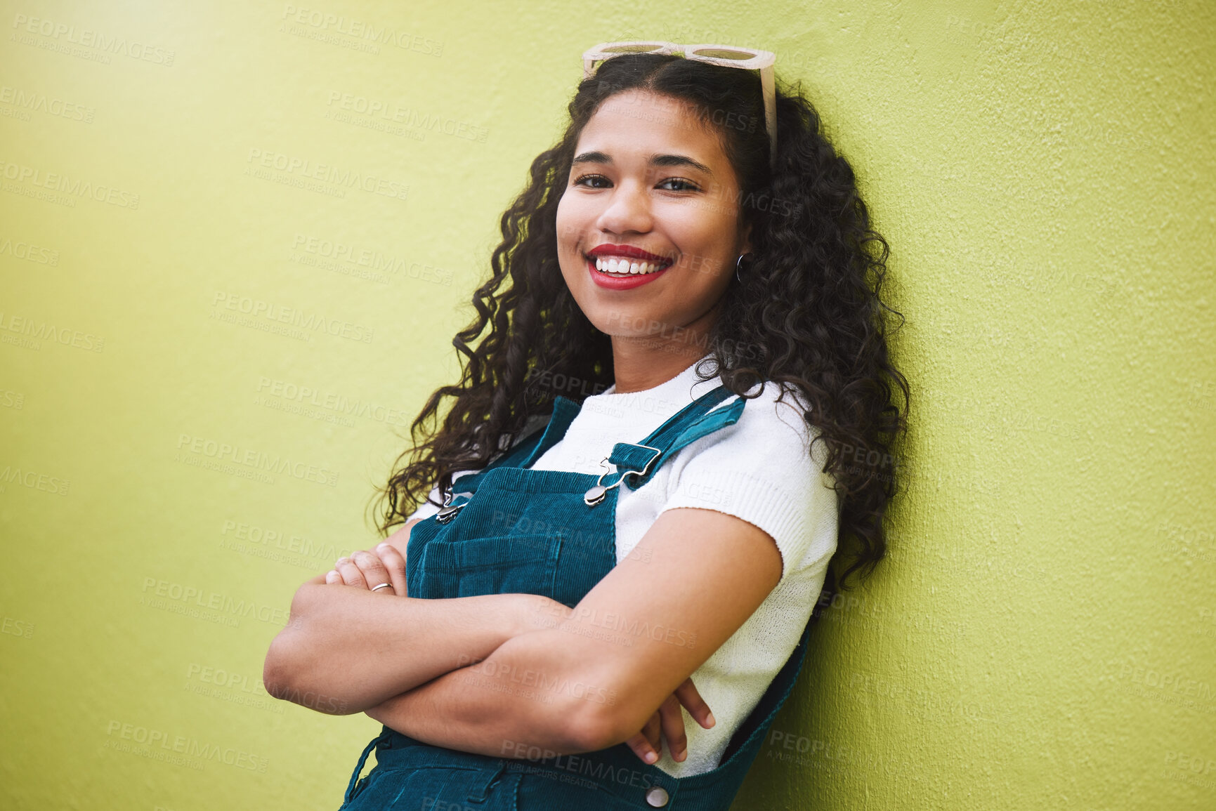 Buy stock photo Girl smile with fashion glasses in hair, show expression of beauty, happiness and confidence. Portrait of beautiful latino woman, happy with arms crossed against green background or wall in the city