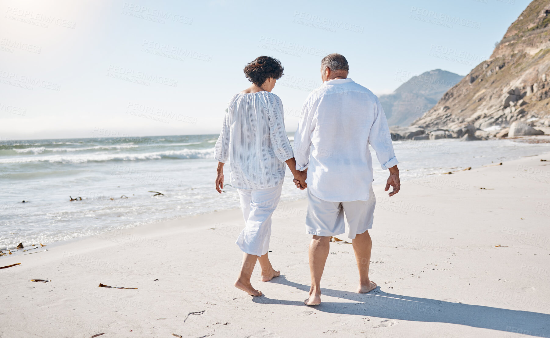 Buy stock photo Holding hands, walking and back of couple on beach for travel, vacation or weekend trip together. Love, anniversary and mature man and woman with connection by ocean for romantic holiday in Cancun.