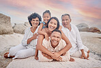 Portrait of a senior hispanic couple at the beach with their children and grandchild. Mixed race family relaxing on the beach having fun and bonding