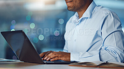 Closeup young african man working on a laptop. African american business man using a computer while working late at night in his office. Putting in overtime after hours to ensure success and growth
