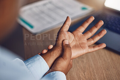 Above closeup hands of young african man as he suffers with wrist or arm pain. African american business man suffering from ache, cramp or arthritis due to working late night overtime after hours