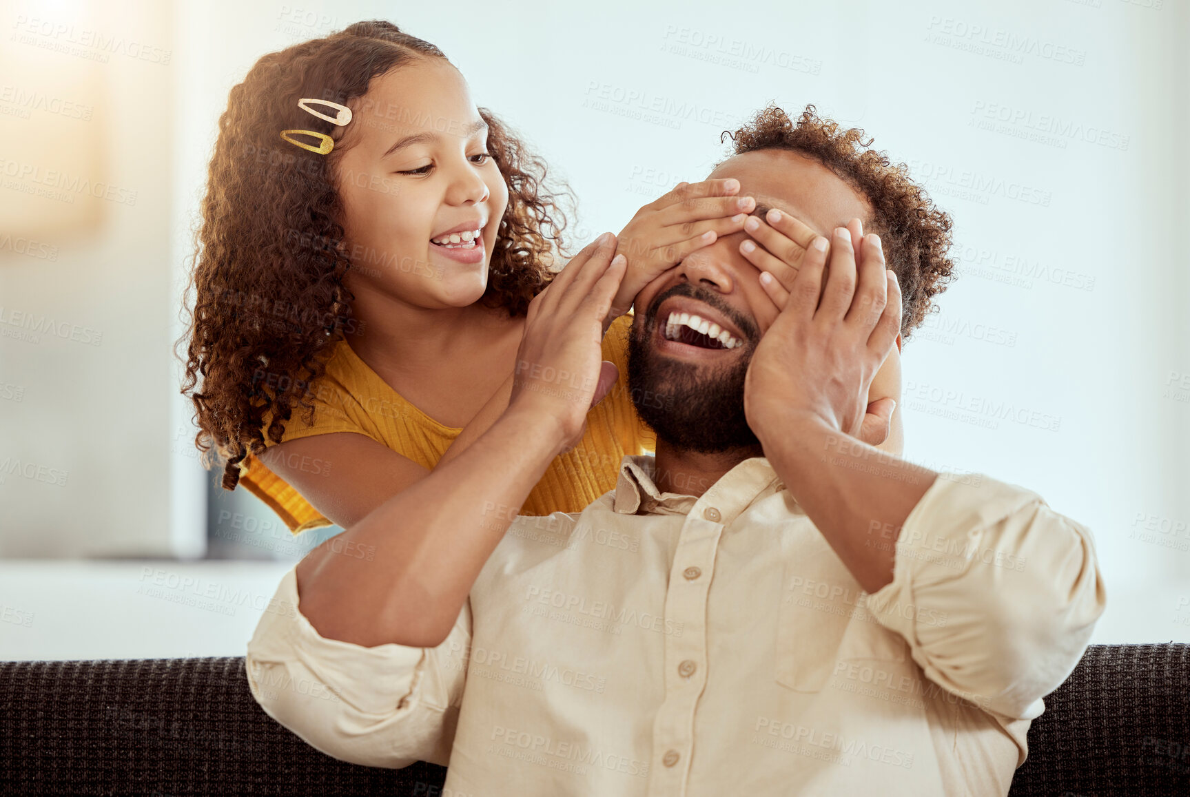 Buy stock photo Mixed race single father and daughter feeling playful in home living room. Smiling hispanic girl bonding and covering single parent’s eyes in lounge. Happy man and child playing hide and seek together