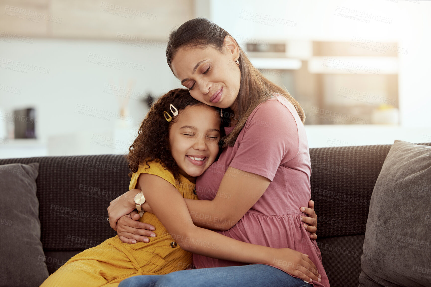Buy stock photo Mixed race single mother and daughter hugging in home living room. Smiling hispanic girl embracing and bonding with single parent in lounge. Happy affectionate woman and child together on weekend