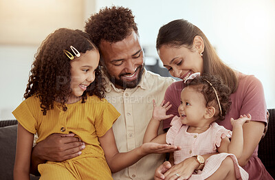 Buy stock photo Smiling mixed race parents enjoying weekend with two adorable daughters in home living room. Hispanic girls and siblings bonding with mother and father in lounge. Happy couple and children together