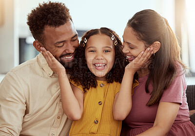 Mixed race parents enjoying weekend with daughter in home living room. Smiling hispanic girl hugging and bonding with mother and father in lounge. Happy affectionate couple sitting together with child