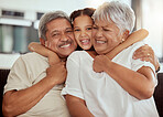 Portrait of mixed race grandparents enjoying weekend with granddaughter in home living room. Smiling hispanic girl bonding with grandmother and grandfather. Happy seniors and child sitting together