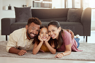 Buy stock photo Portrait of mixed race parents enjoying weekend with cute daughter in home living room. Smiling hispanic girl bonding with mother and father in lounge. Happy couple lying together with kid on weekend