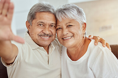 Portrait of smiling mixed race senior couple taking selfie at home. Happy hispanic husband and wife taking picture for social media at home. Elderly man and woman bonding while taking photo for memory