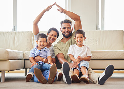 Buy stock photo Portrait of a young couple ensuring that their family's home is covered. Hispanic parents smiling and making a roof gesture with their hands over their two sons in the lounge at home