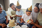 Mixed race family celebrating a birthday and having come cake at home in the loung. Hispanic relatives enjoying some sweet cake and smiling at home