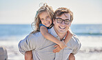Portrait of happy caucasian father with glasses giving his daughter a piggyback ride on his back at the beach on a sunny day. Loving dad and little girl spending time together while on holiday