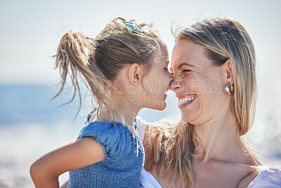 Buy stock photo Adorable little daughter and mother rubbing noses while spending time together at the beach while on vacation. Cheerful mom and little girl having fun outdoors on a sunny day