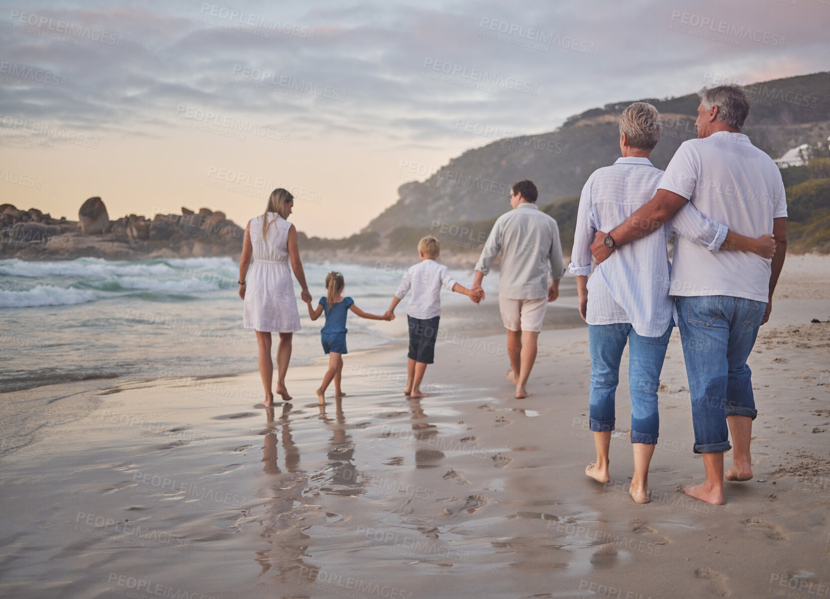 Buy stock photo Family, generations and back with walking, beach and sunset with men, women and children with love. Parents, grandparents and kids by ocean, holding hands and bond on summer vacation with solidarity