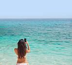 Beautiful woman taking photos with smart phone technology on paradise beach destination summer wanderlust vacation