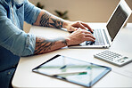 businessman with tattoos using latop computer typing messages browsing online working sitting at table