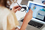 business woman hands holding glasses with laptop computer showing financial data on screen