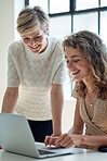 two business women using laptop computer working in office team leader sharing ideas with colleague on screen