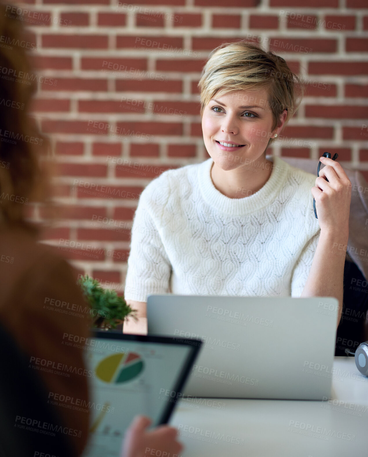 Buy stock photo beautiful business woman using laptop computer working in office sharing ideas with colleague discussing financial information on tablet screen